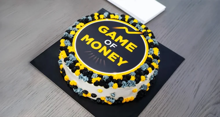 Game of Money branded celebration cake featuring the logo